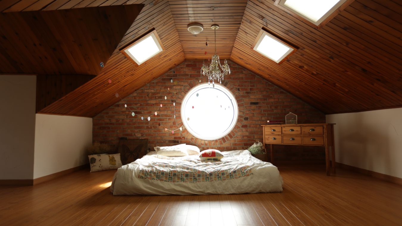 Finished attic bedroom conversion with exposed brick and skylights