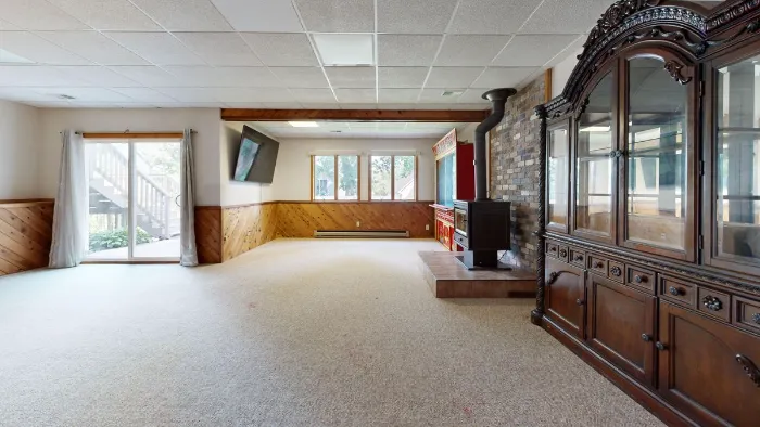 Basement family room with wood paneling and a fireplace