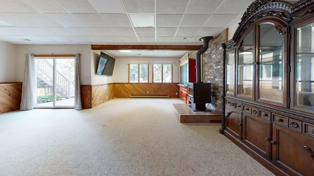 Basement family room with wood paneling and a fireplace