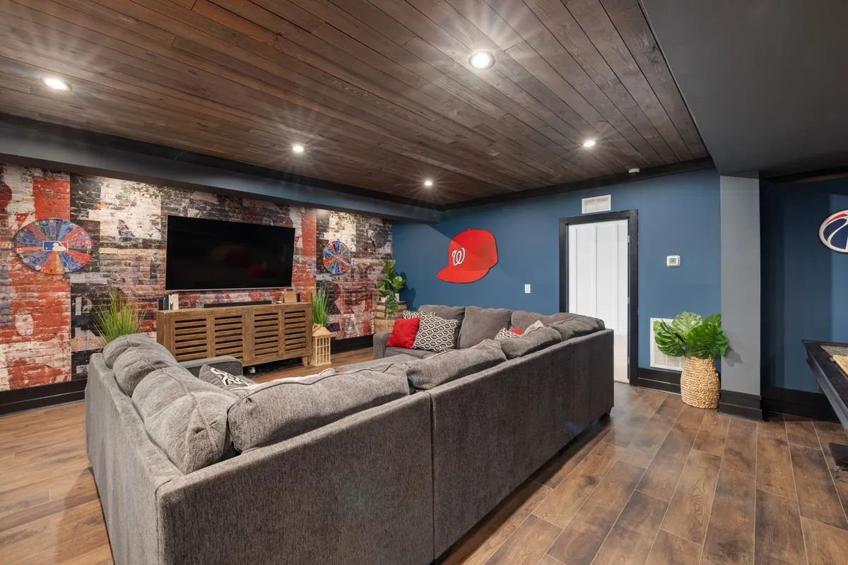 Finished basement living room with a large television and sectional sofa