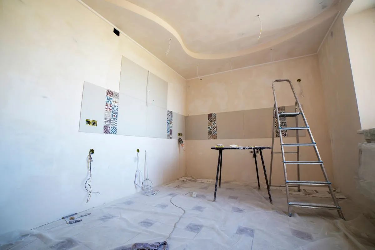 Room under renovation with a ladder and drywall