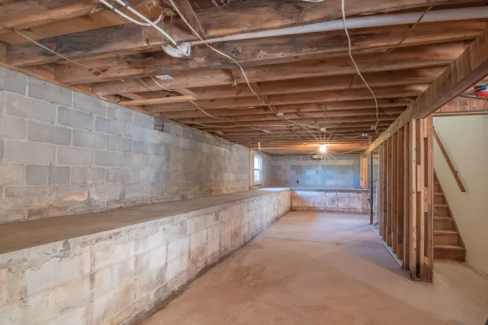 Unfinished basement with block walls and exposed floor joists