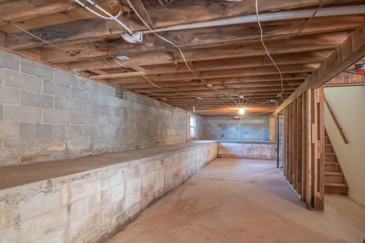 Unfinished basement with block walls and exposed floor joists